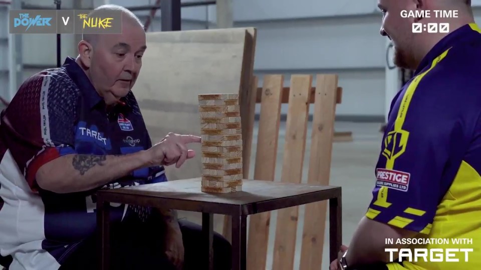 Phil Taylor and Luke Littler playing Jenga.