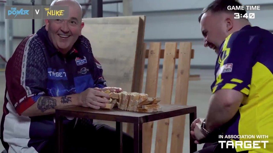 Phil Taylor and Luke Littler playing a game.