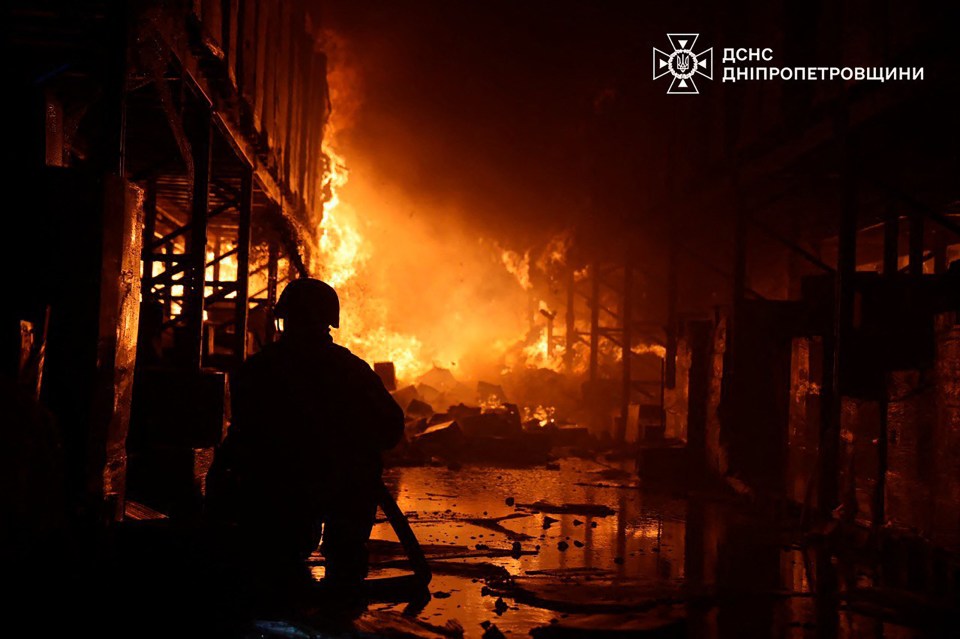 Ukrainian rescuer fighting a fire at a Russian missile strike site in Dnipro.