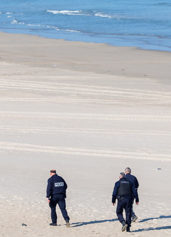 Two police officers patrolling a beach.