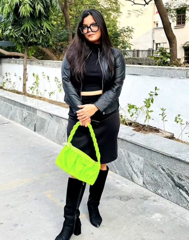 Misha Agrawal, social media influencer, in black outfit and lime green handbag.