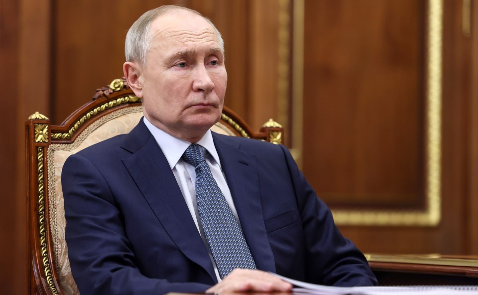 Vladimir Putin seated at a meeting.