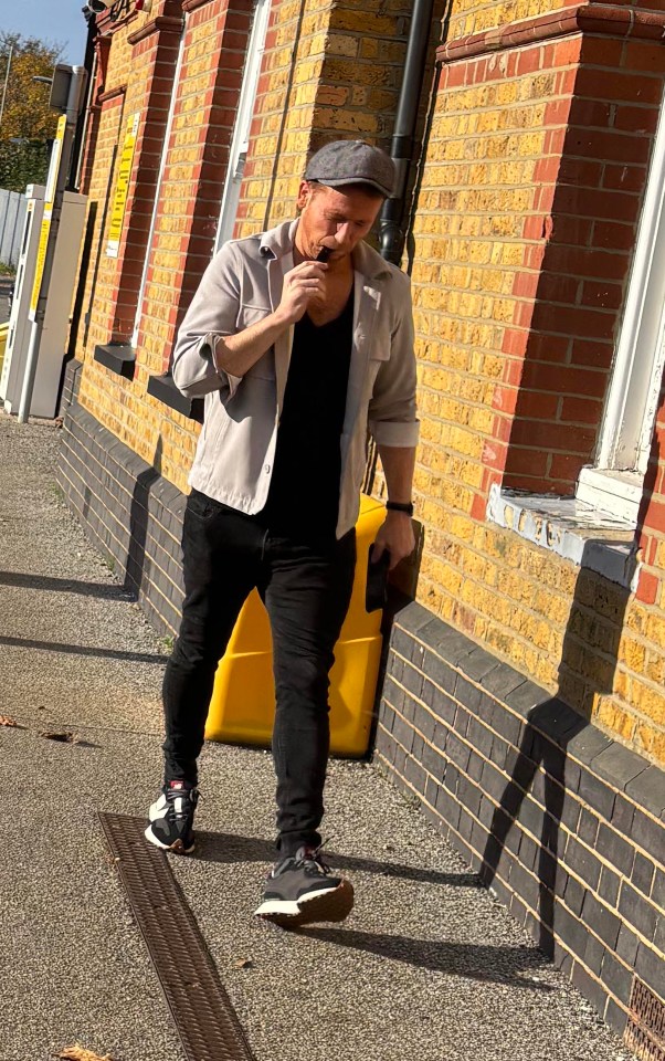 Man walking down a sidewalk, appearing upset.