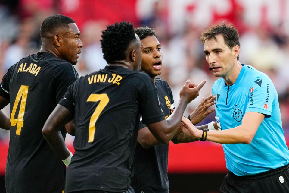 Soccer referee speaking with Real Madrid players.