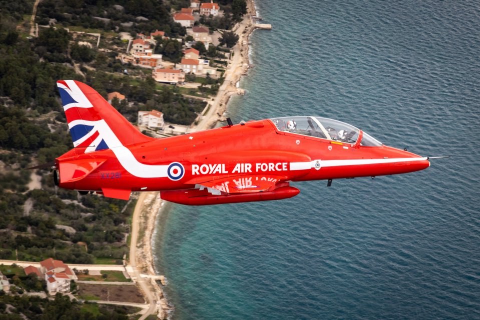 Red Arrows jet flying over the coast.