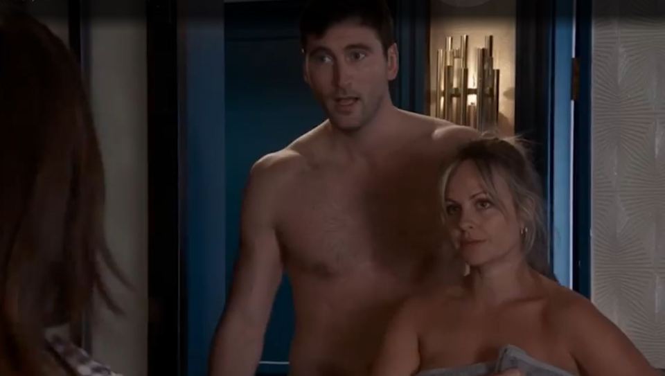 A shirtless man and a woman wrapped in a towel.