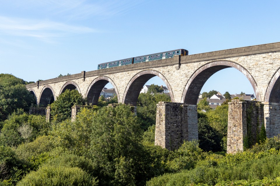 Train crossing a stone viaduct.