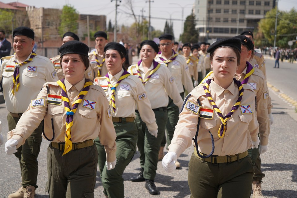 Scouts marching in a parade.