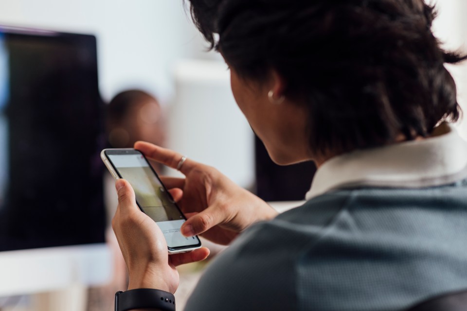 Young man in an office using a smartphone.