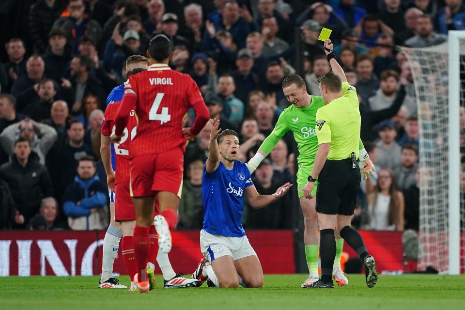 Referee showing Everton player a yellow card.