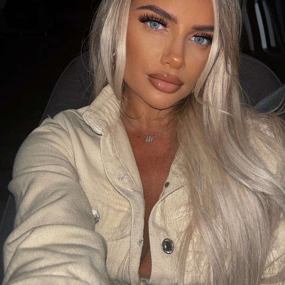 Woman with blonde hair wearing a beige jacket.