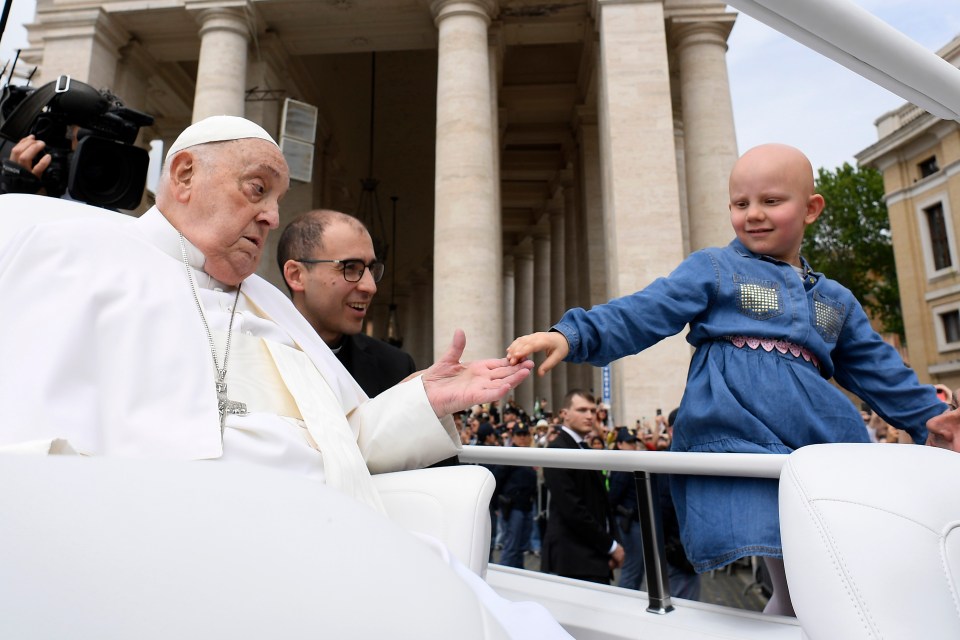 Pope Francis greets a young girl during Easter Mass.