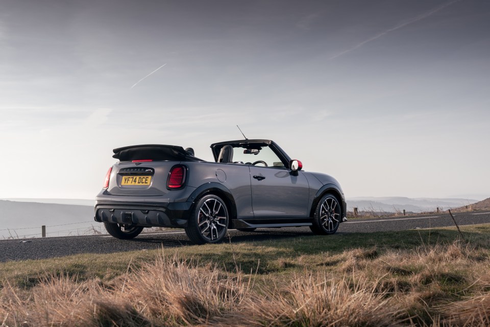 Gray Mini Cooper convertible parked on a roadside.