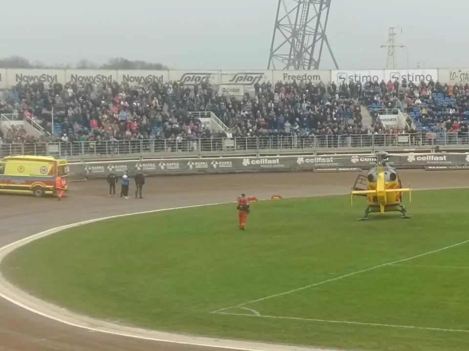 Helicopter and ambulance at a stadium.