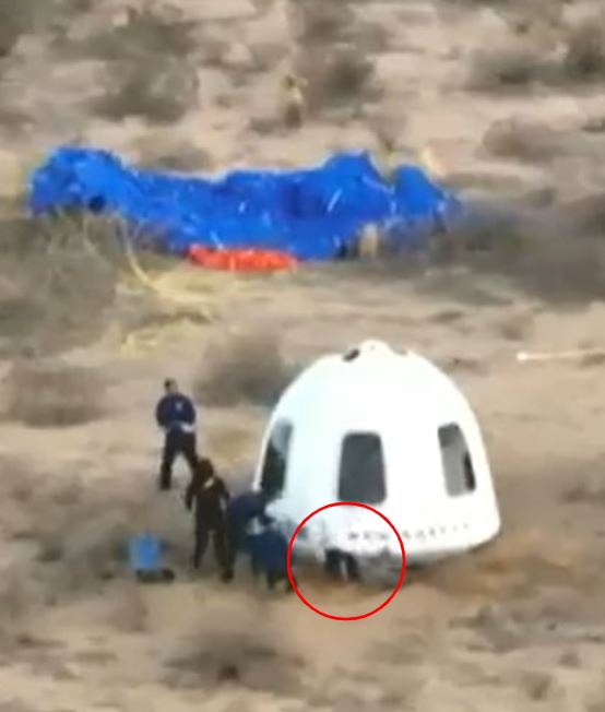 People retrieving a spacecraft from the desert.