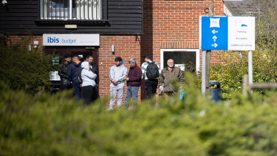 People standing outside an Ibis Budget hotel.