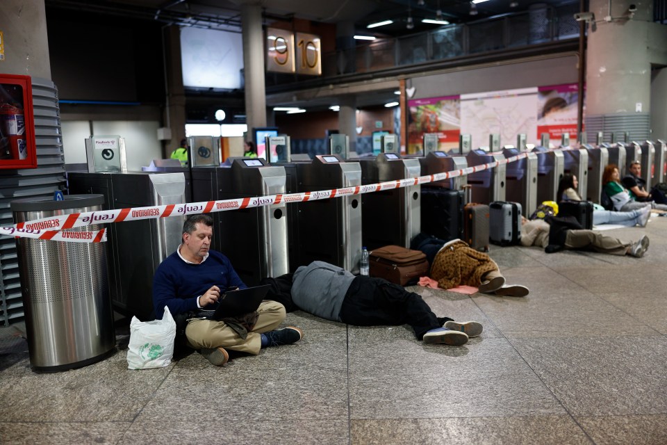 Train station passengers sleeping on the floor after a power outage.