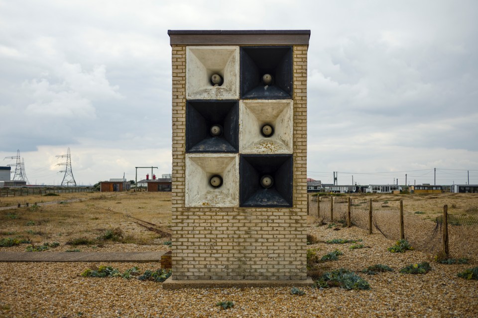 Checkerboard sound mirror on a shingle beach.