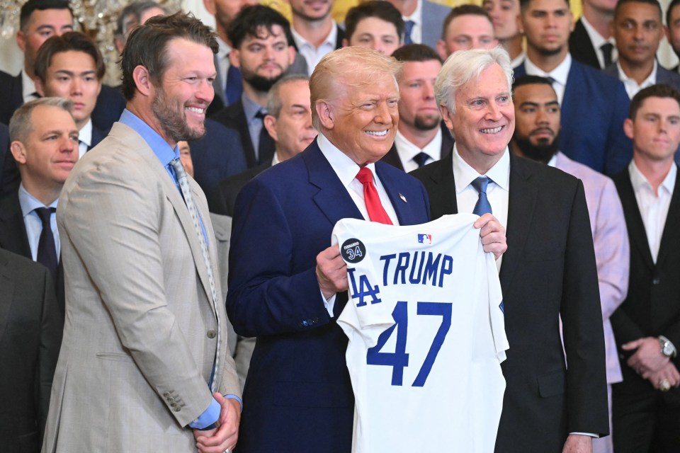 President Trump holding a Los Angeles Dodgers jersey with other people.