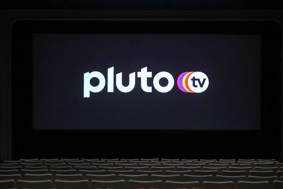Pluto TV logo displayed on a movie screen in an empty theater.