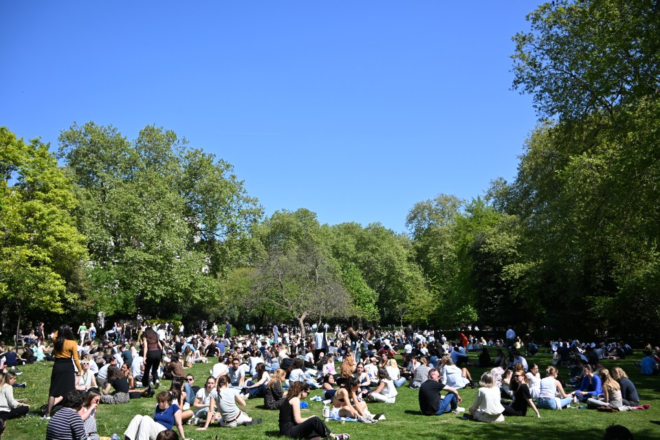 Crowds of people enjoying a sunny day in Lincoln's Inn Fields.