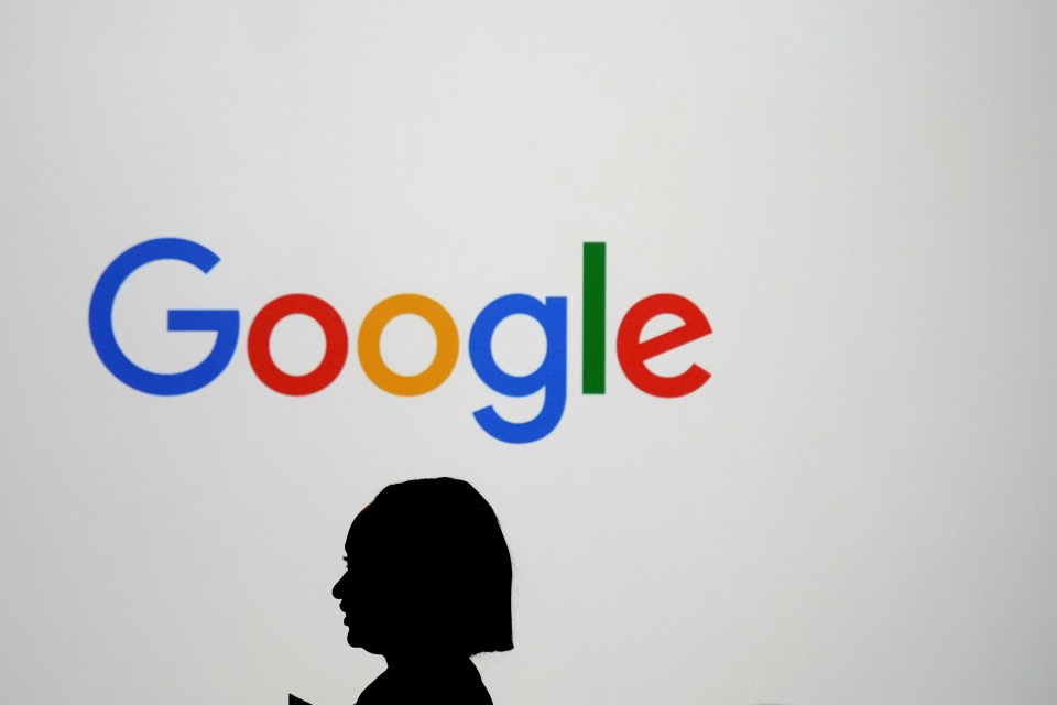 Woman silhouetted against a large Google logo.