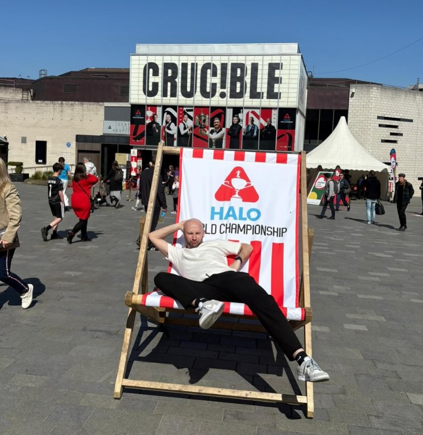 Man relaxing in a deck chair outside the Crucible Theatre during the Halo World Championship.