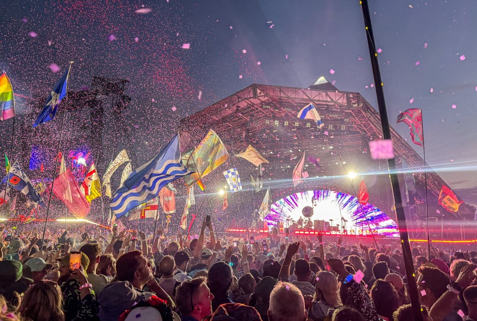 Crowd at Glastonbury Festival with confetti falling.