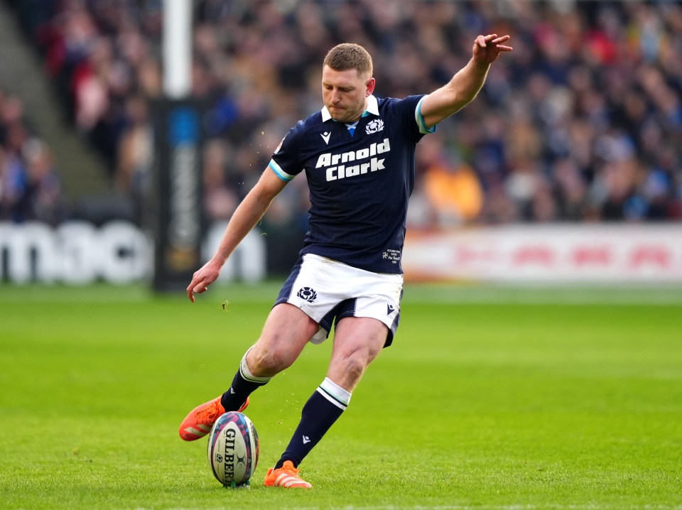 Finn Russell kicking a rugby ball.
