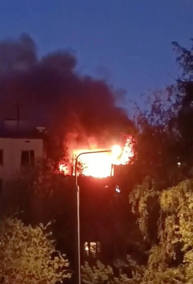Highrise building engulfed in flames at night.