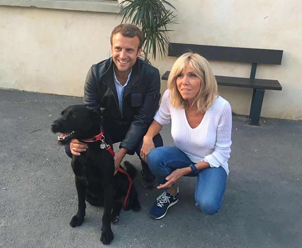 Emmanuel Macron and Brigitte Macron adopting a dog.