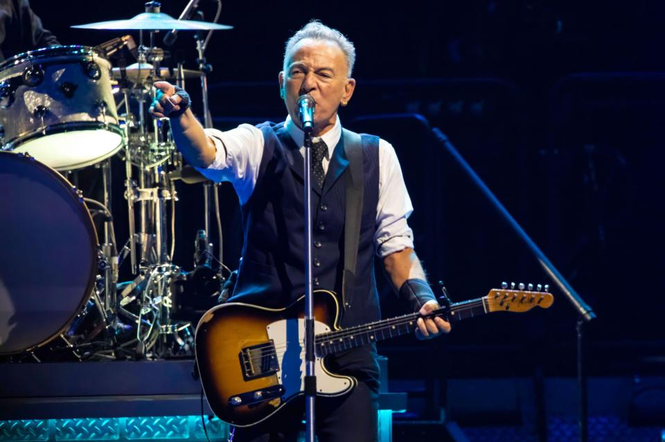 Bruce Springsteen performing on stage with the E Street Band.