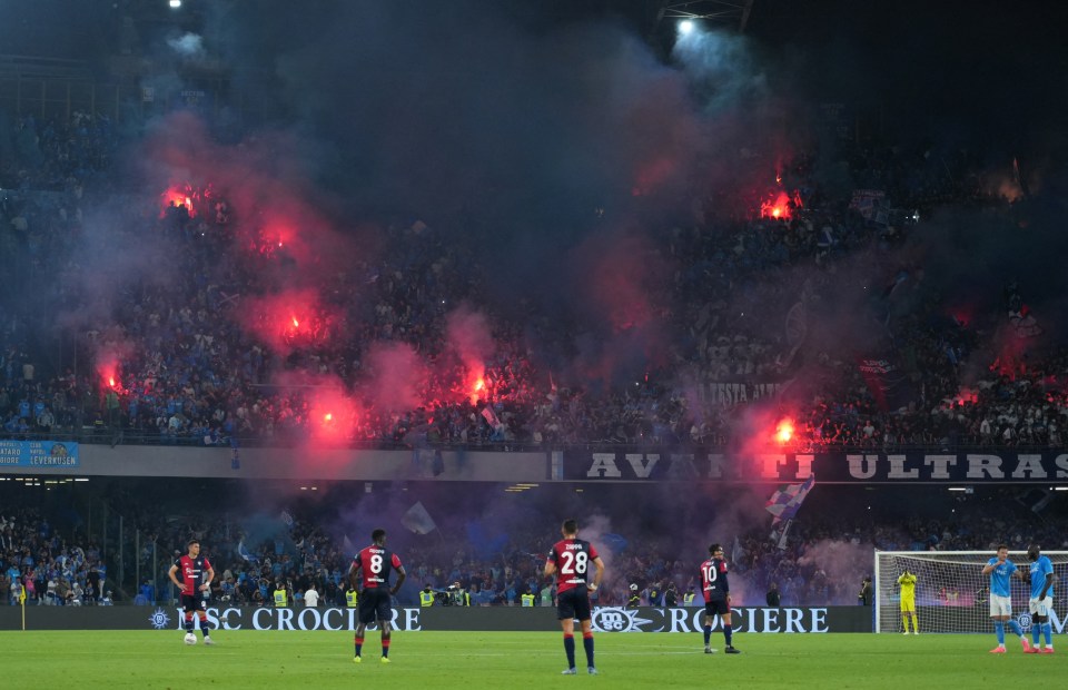 Napoli fans celebrating with flares during a soccer match.