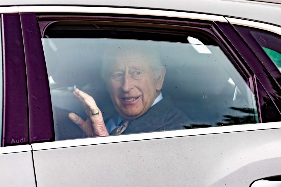 King Charles seen waving from a car window.