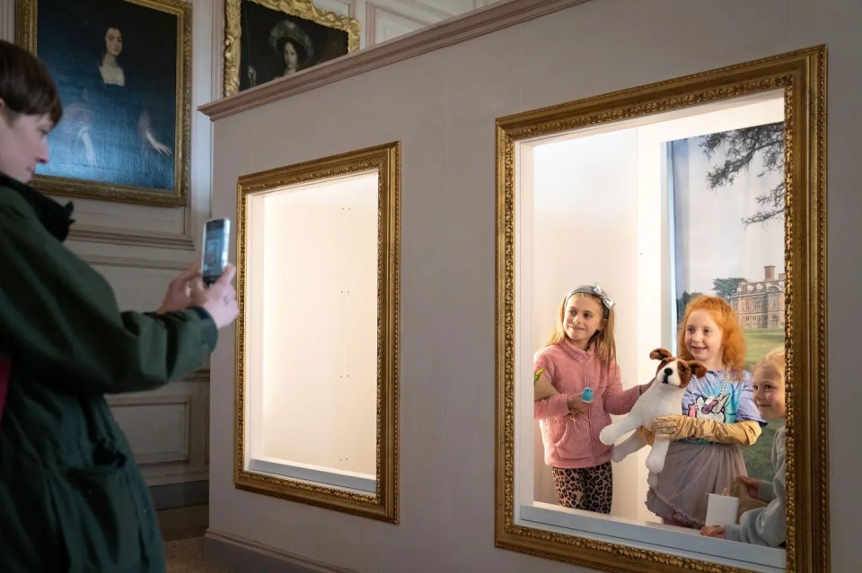 Person photographing children in ornate picture frames.