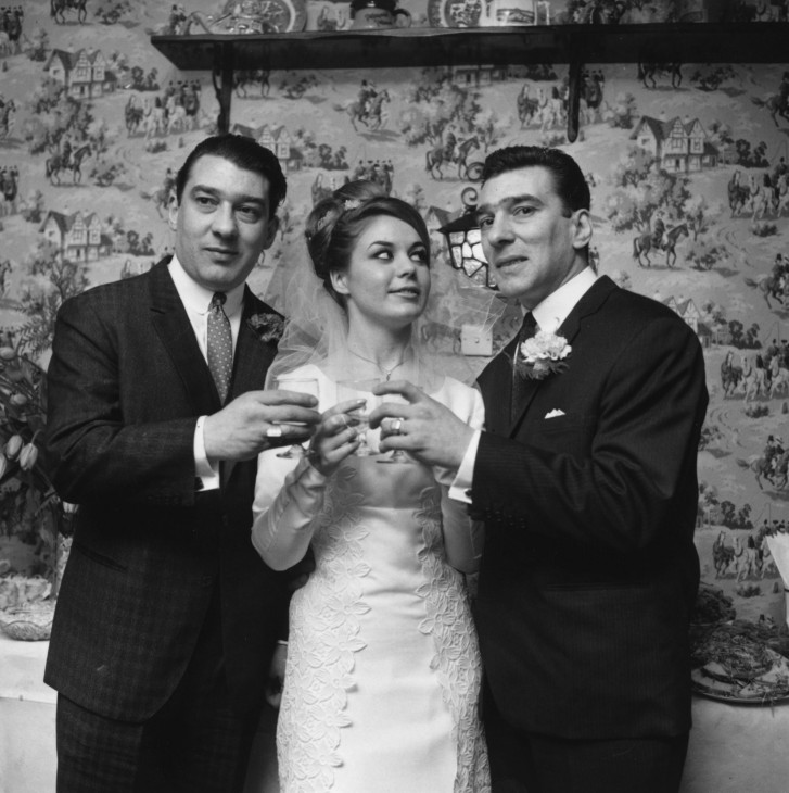 April 1965: Frances Shae toasting to future happiness with the Kray twins, after her marriage to Reggie Kray, right. (Photo by Norman Potter/Express/Getty Images)
