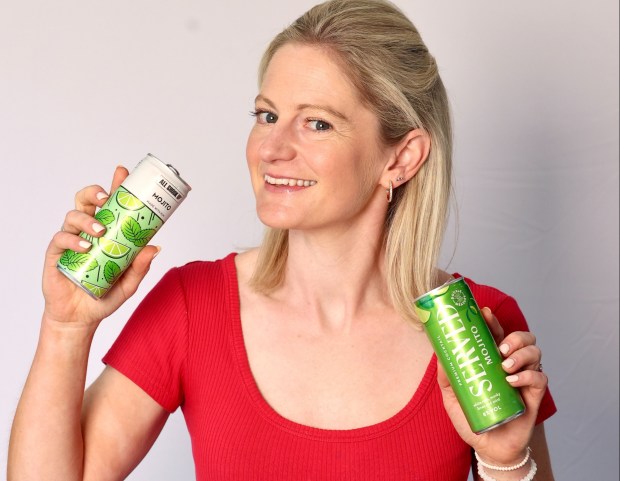 Woman holding various canned mojitos.