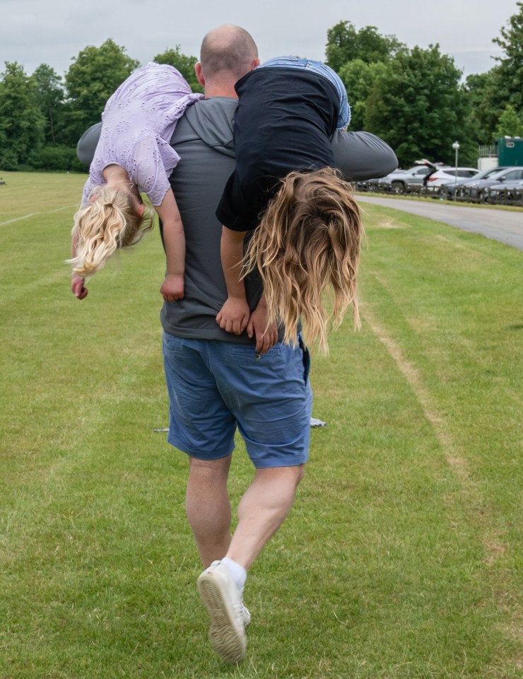 Man carrying two children on his shoulders.