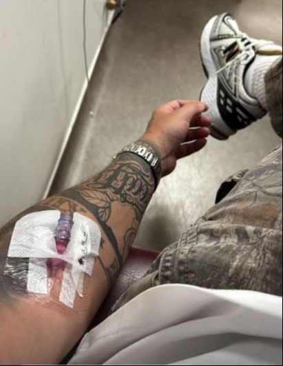 Person with an IV in their arm in a hospital.