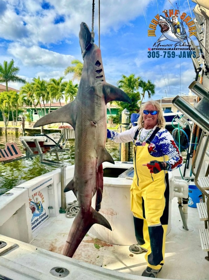 Captain Mark "The Shark" Quartiano with a large hammerhead shark.