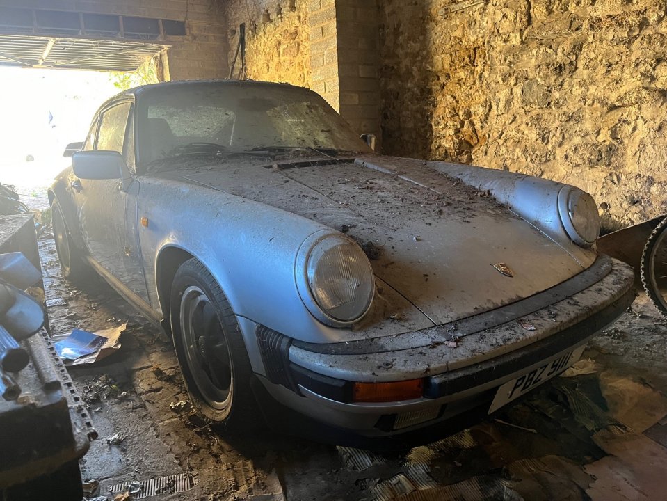 Dusty Porsche 911 Carrera in a garage.