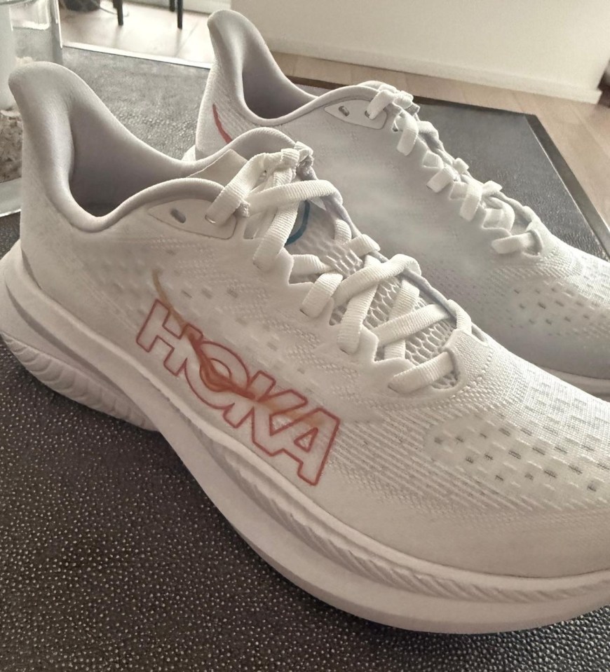 Pair of white Hoka running shoes.