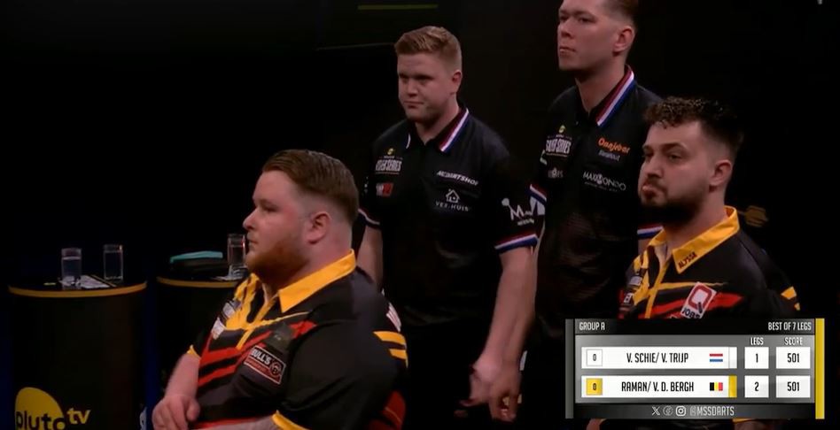 Four darts players during a match.