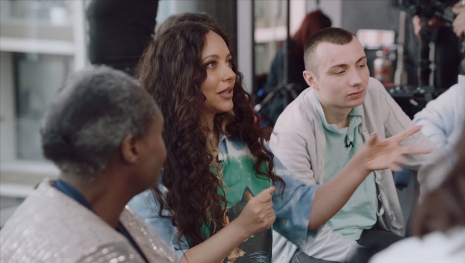 Jade Thirlwall speaking with a group of people.