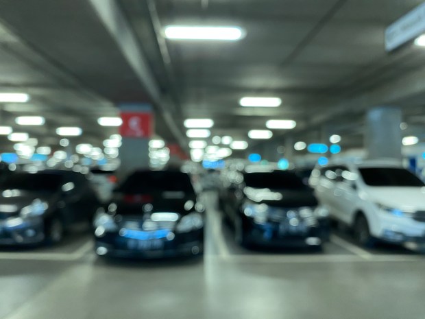 Blurred photo of cars parked in a parking garage.
