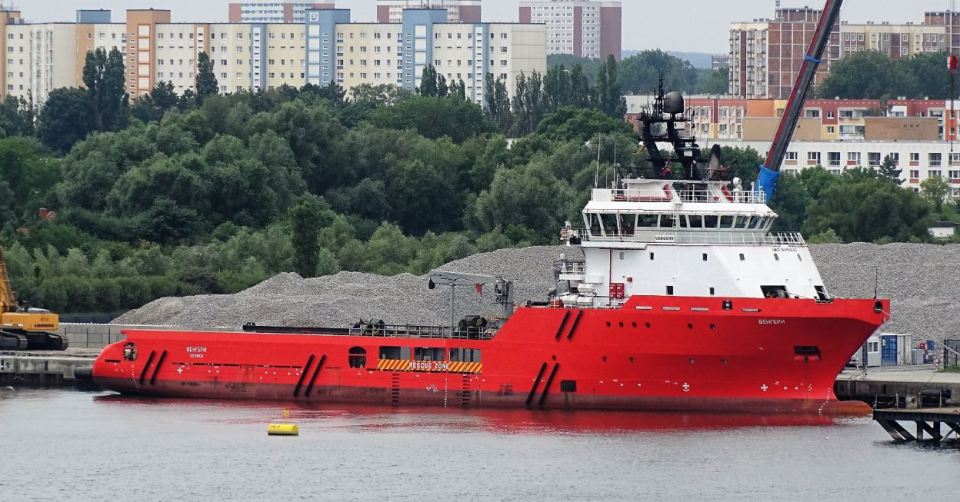 Red Vengery ship docked near a shore.