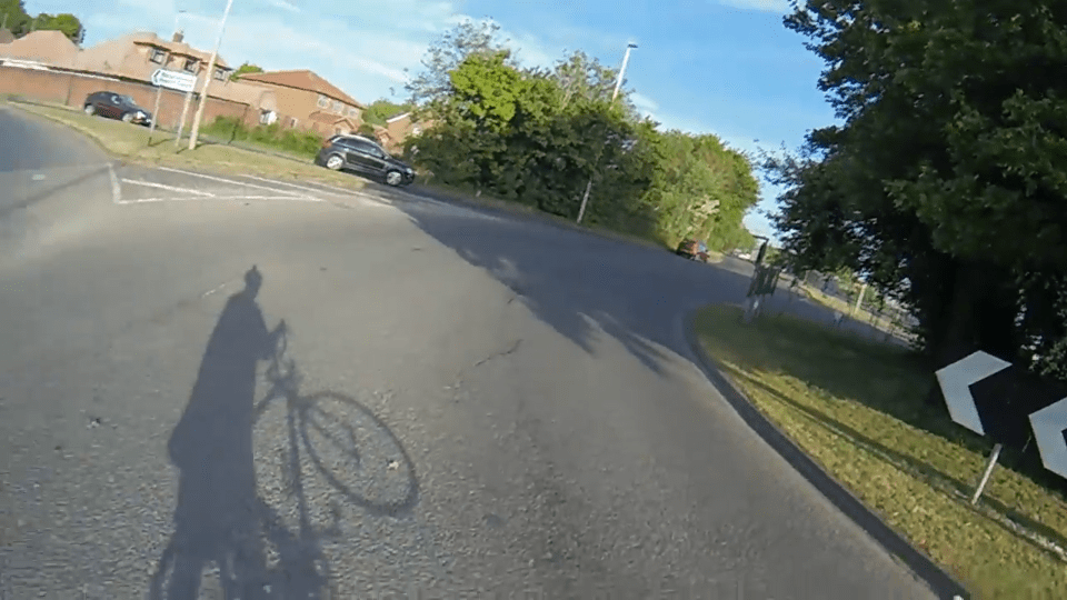 Shadow of cyclist on road near intersection.