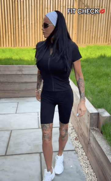 Screenshot of a person wearing a black athletic outfit and white sneakers, walking outdoors.