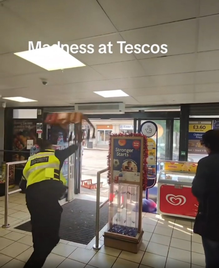 Security guard throwing a tray at two men in a Tesco store.