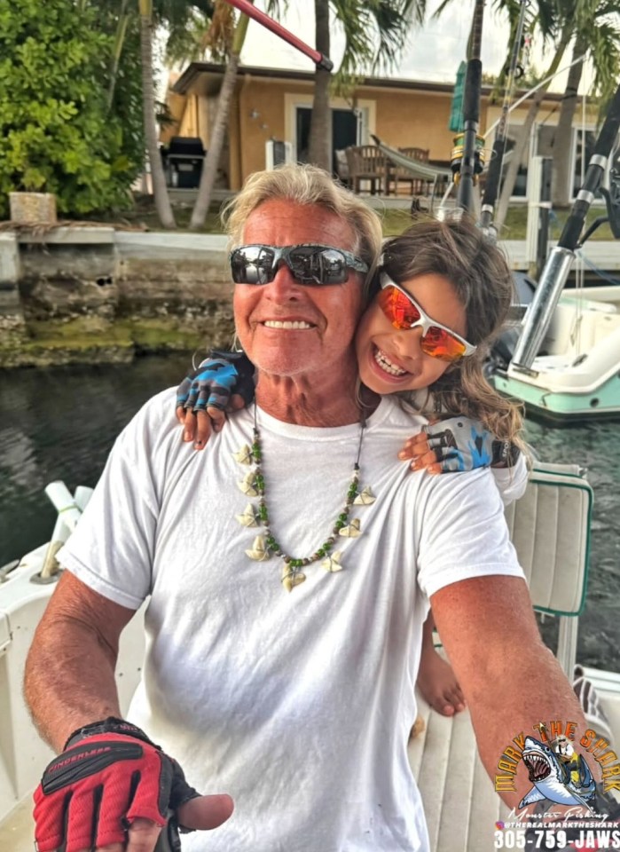 Captain Mark "The Shark" Quartiano with a child on a boat.